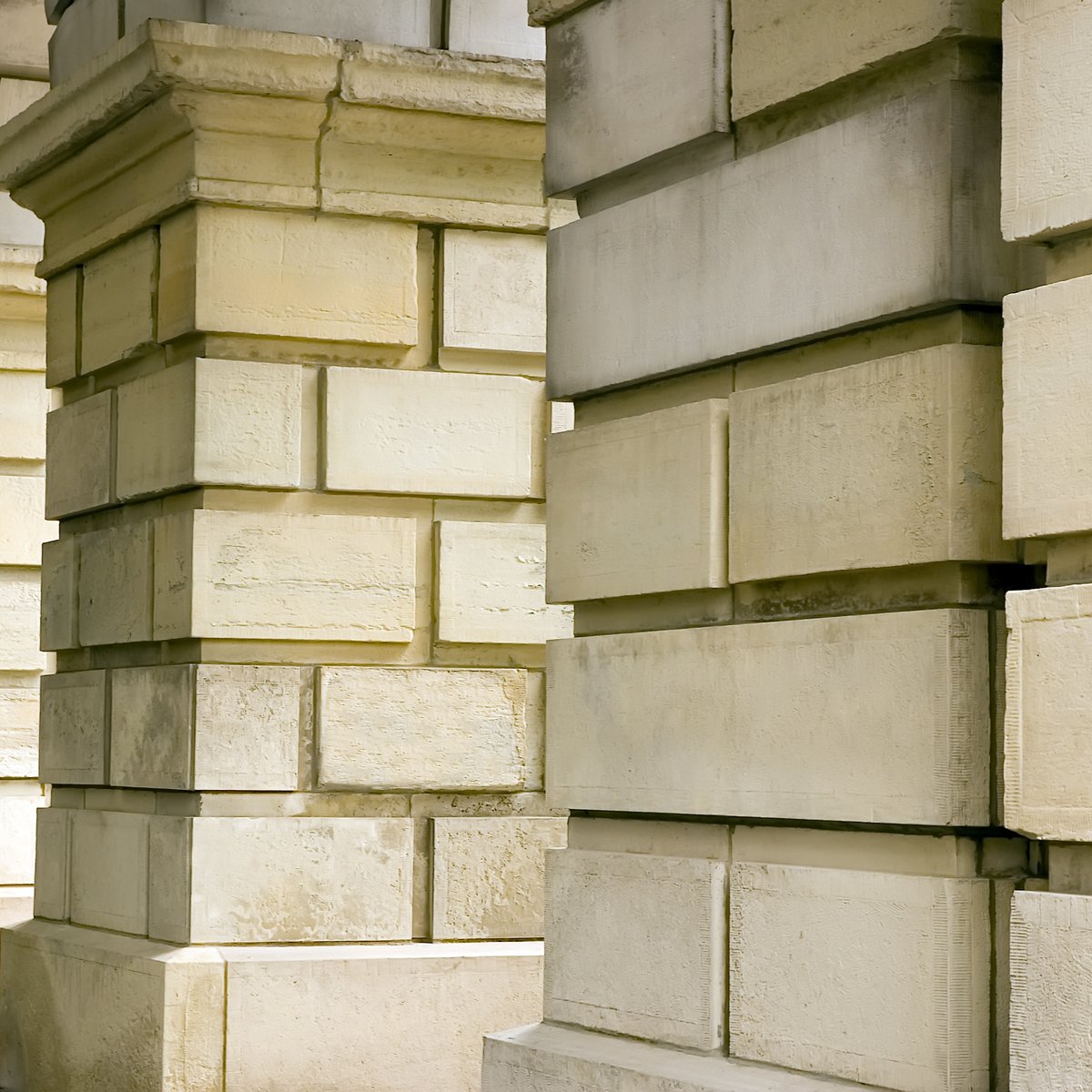 Rusticated cream limestone ashlar piers on a classical greystone building facade - greystone and limestone restoration in Chicago, IL by MasonryPros.us